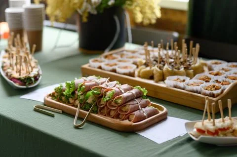 Assorted appetizers on table with fresh ingredients and desserts displayed Stock Photos