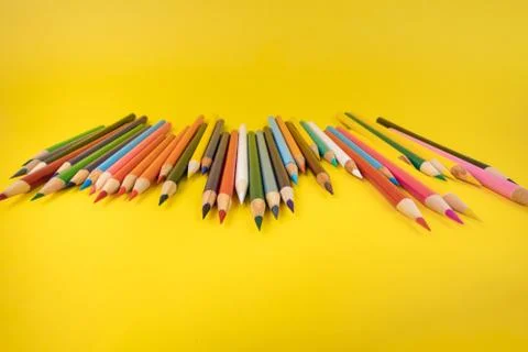 Assorted art coloring pencils sharpened on bright yellow background Stock Photos