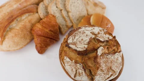 Assorted Artisanal Breads and Pastries on White Background Stock Footage 338421000