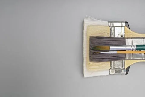 Assorted artistic paintbrushes of different sizes placed on a gray background Stock Photos