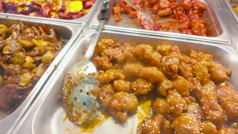 Assorted Asian buffet hot trays with mushroom stir-fry and orange chicken Видео 331289320