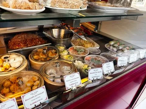 Assorted Asian dim sum, noodles and salads in a glass deli counter at a Par.. Stock Photos
