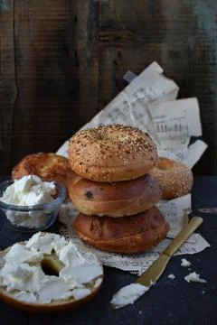 Assorted Bagels with cream cheese on rustic table with music sheets Stock Photos