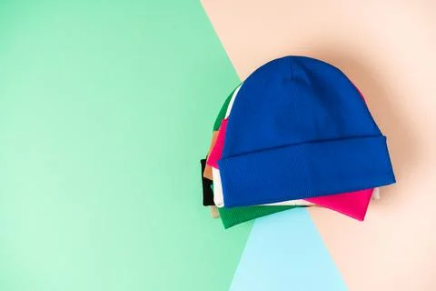 Assorted beanie hats in different bright youth colors are stacked Stock Photos