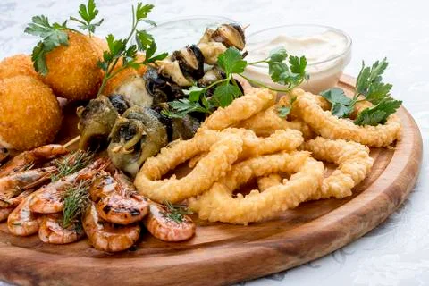 Assorted beer snacks. Cheese balls, mussels grill, shrimp, squid rings. Stock Photos