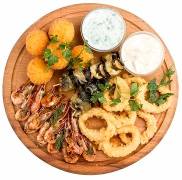 Assorted beer snacks. Cheese balls, mussels grill, shrimp, squid rings. Stock Photos