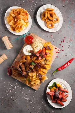 Assorted beer snacks: chips, sausages, onion rings, chicken nuggets, croutons Stock Photos
