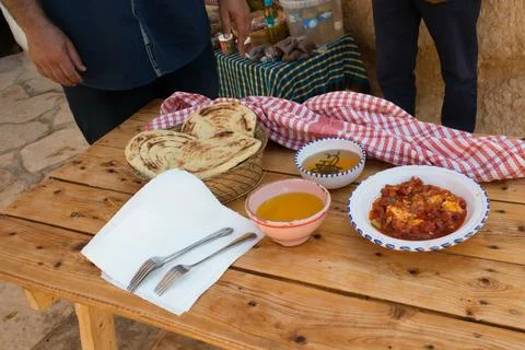 Assorted bereber food on a table, flatbread, olive oil, honey and vegetables Stock Photos