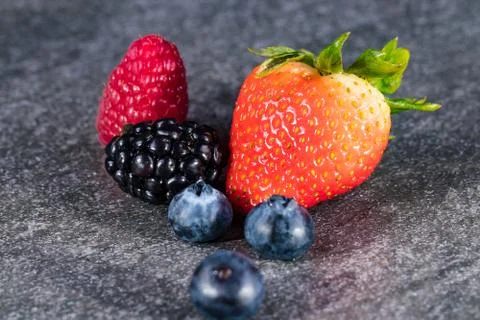 Assorted berries on gray stone 写真素材