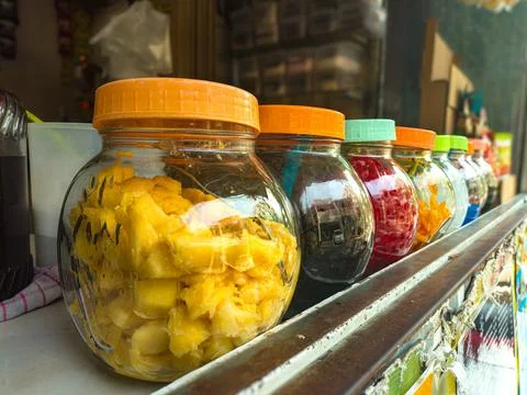 Assorted beverage toppings in clear jars with vibrant lids lined up, offeri.. Stock Photos