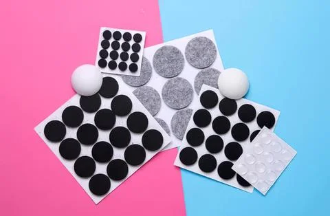 Assorted black and gray adhesive dots on colorful background Stock Photos