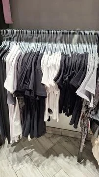 Assorted black and white pants on display in retail store Stock Photos