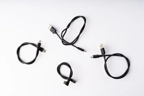 Assorted Black USB Charging Cables on White Background Stock Photos