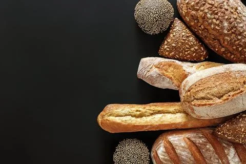 Assorted bread and rolls on black background Foto stock
