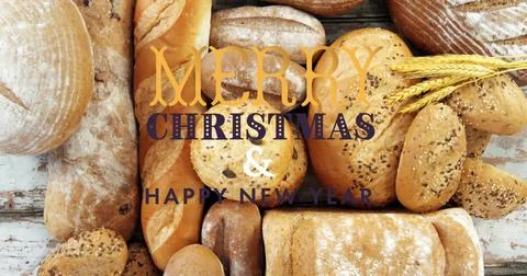 Assorted bread loaves sitting on rustic wooden tabletop, featuring holiday text 스톡 사진