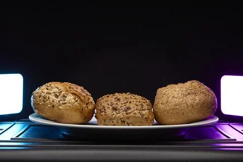 Assorted bread rolls side by side on plate with colorful light Foto stock