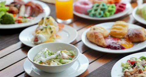 Assorted breakfast buffet on wooden table, featuring eggs benedict, Stock Footage 312000477