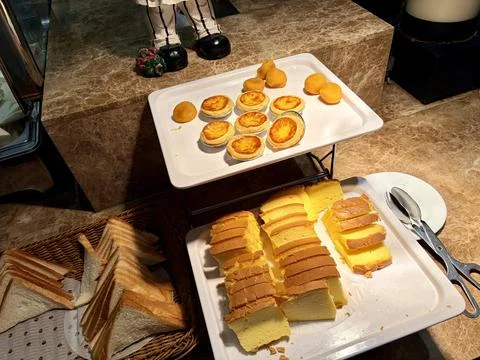 Assorted Breakfast Pastries and Sliced Bread on Buffet Table 스톡 사진