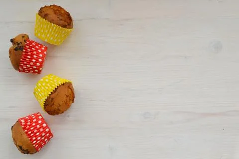 Assorted bright coloured decorative cupcakes on shabby wooden background with Stock Photos