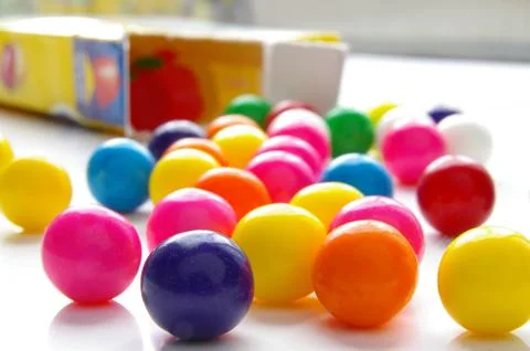 Assorted brightly colored candy gum balls and box Stock Photos