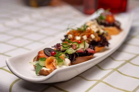 Assorted bruschetta with different flavors on a white plate on the table Stock Photos