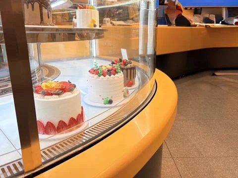 Assorted cakes in a bakery display case. Stock-Fotos