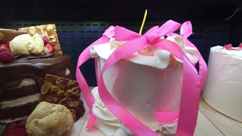 Assorted cakes with icing and decorations on display. Close-up of a cake Stock Footage 283402199