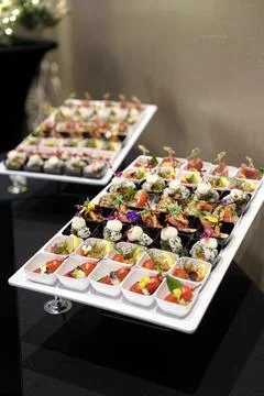 Assorted catering snacks in individual white boxes on serving trays Stockfoto's