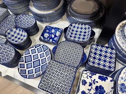 Assorted ceramic dinnerware with intricate blue patterns displayed on shelves Stock Photos