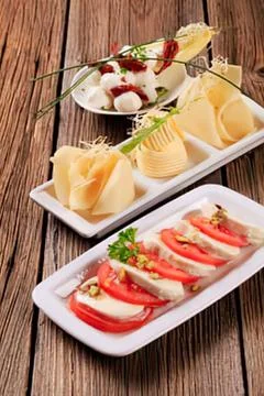 Assorted cheese and fruit appetizers on wooden table Stock Photos