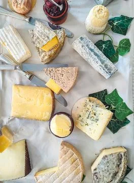 Assorted cheese platter featuring different French cheese varieties, knives,  Stock Photos