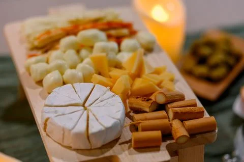 Assorted cheese platter with various cheeses and garnishes on wooden board Stock Photos