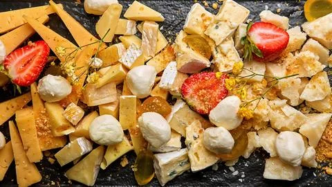 Assorted cheese with strawberries on a plate Stock Photos