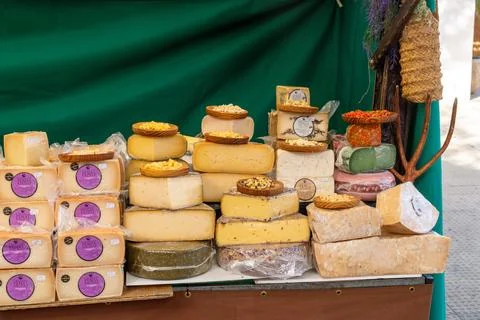 Assorted cheese wheels and blocks at a market stall Foto stock