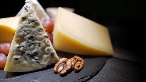 Assorted cheeses with nuts and dried fruits on the table. Rotating video Stock Footage 116879116