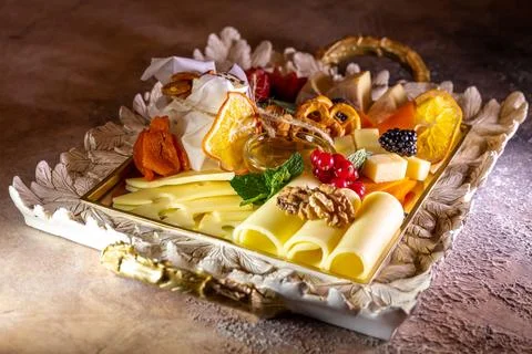 Assorted cheeses on a tray with nuts and honey Stock Photos