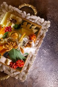Assorted cheeses on a tray with nuts and honey Stock Photos