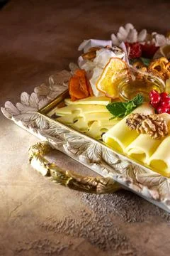 Assorted cheeses on a tray with nuts and honey Stock Photos