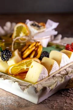 Assorted cheeses on a tray with nuts and honey Stock Photos