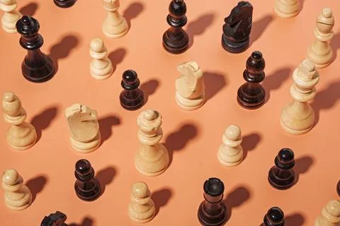 Assorted chess pieces on an orange background with shadow Stock Photos