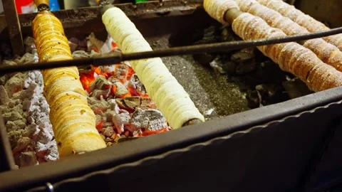 Assorted Chimney Cakes Spinning With Toppings in Open Market Stock Footage 324001975