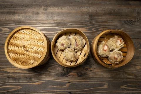 Assorted chinese dim sum dumpling on bamboo wooden basket bowl on wooden tabl Stock Photos