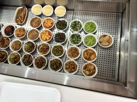 Assorted Chinese Side Dishes Displayed in a Cafeteria Counter 스톡 사진