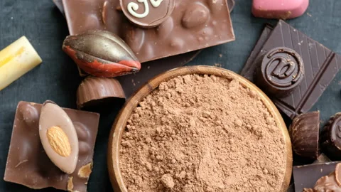 Assorted chocolate and cocoa on black background, close up Stock Footage 102417429