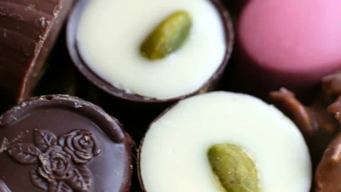 Assorted chocolate and cocoa on black background, close up. High angle view Stock Footage 102423486