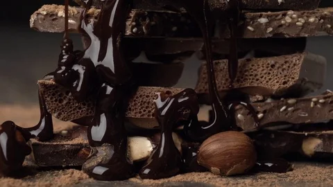 Assorted chocolate and nuts covered with chocolate topping Video stock 84388442