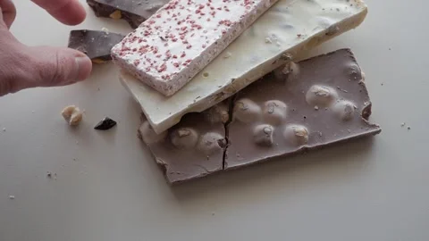 Assorted Chocolate Bars Stacked Calmly on a White Background Stock Footage 321739205