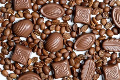 Assorted chocolate candy on the background of coffee beans isolated Stock Photos