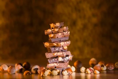 Assorted chocolate chunks with hazelnuts and almonds stacked forming a tower  Stock Photos