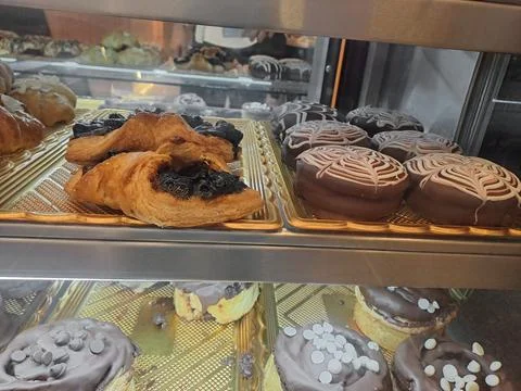 Assorted Chocolate Donuts and Fruit Jam Pastries in Bakery Showcase Stock Photos
